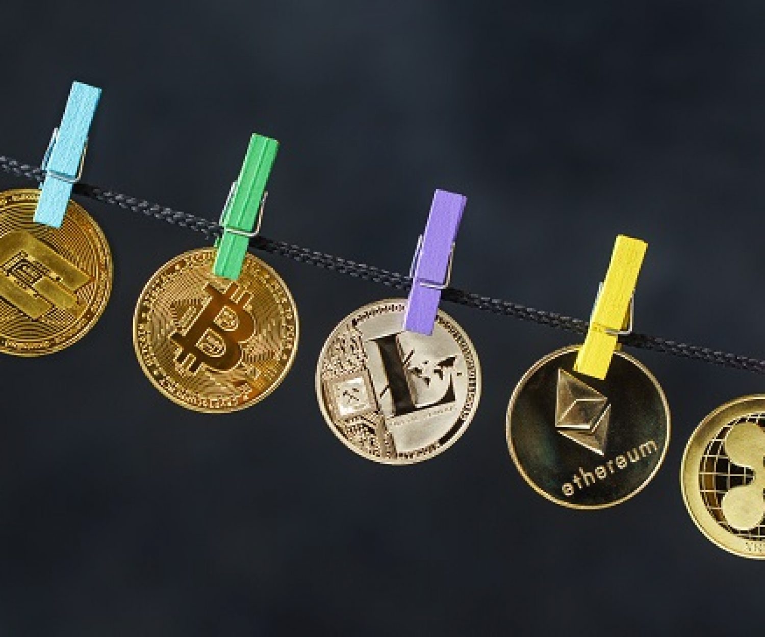 Various cryptocurrencies hanging on rope with clothes pins